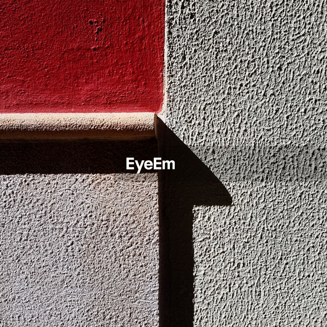 CLOSE-UP OF WALL WITH SHADOW OF BRICK WALLS ON CONCRETE