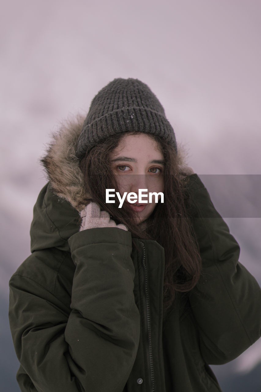 Portrait of young woman standing in snow