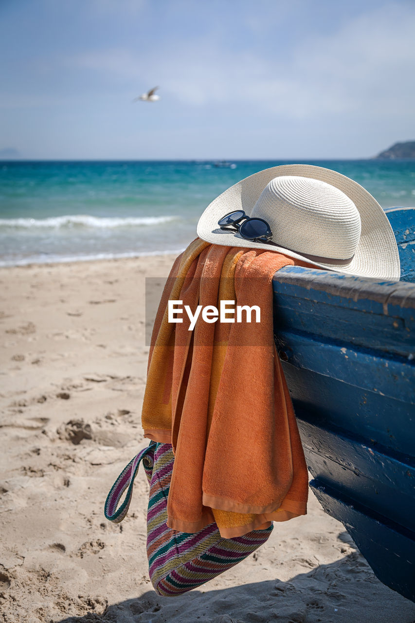 Hooded chair on beach against sea