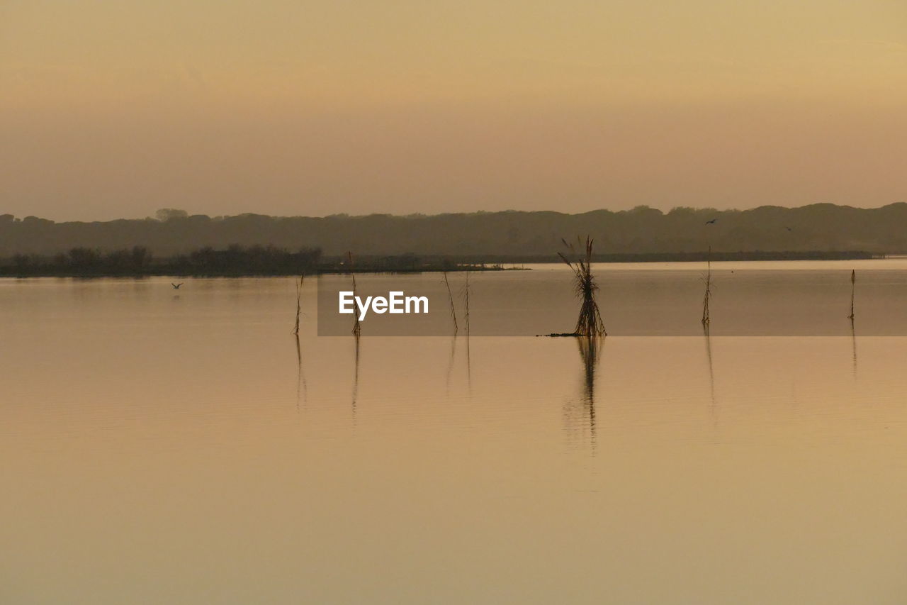 SCENIC VIEW OF LAKE AGAINST ORANGE SKY