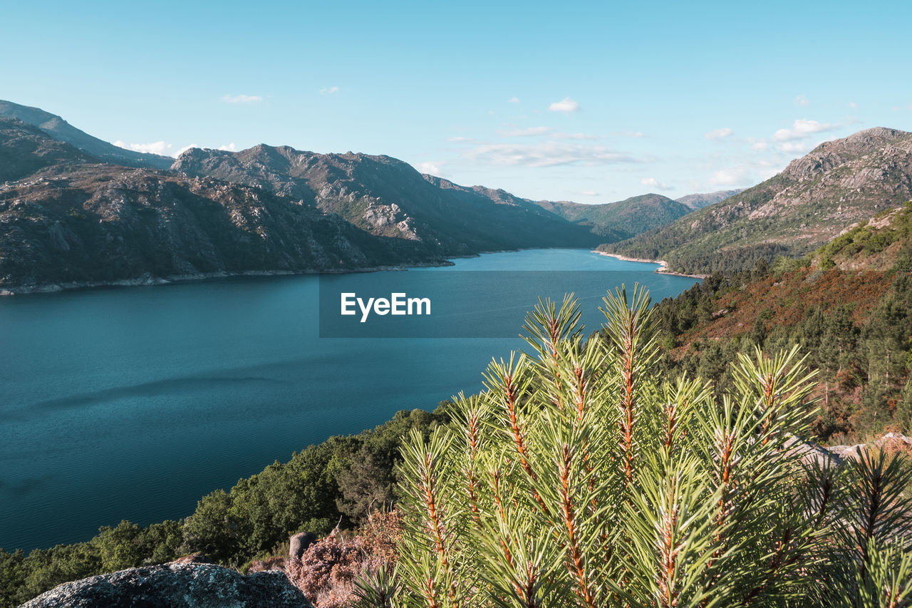 SCENIC VIEW OF BAY AGAINST MOUNTAINS