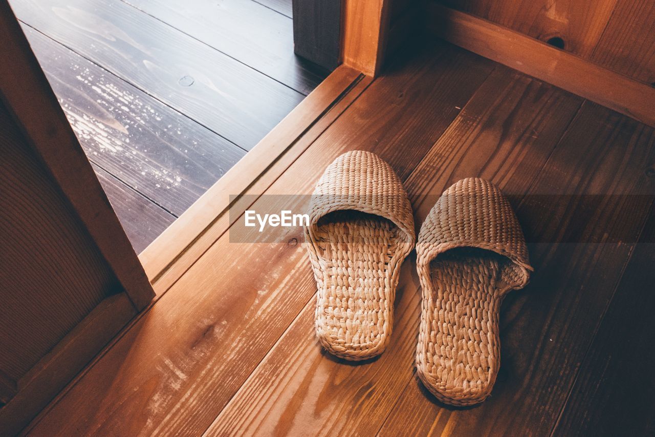 High angle view of wicker slippers on floorboard