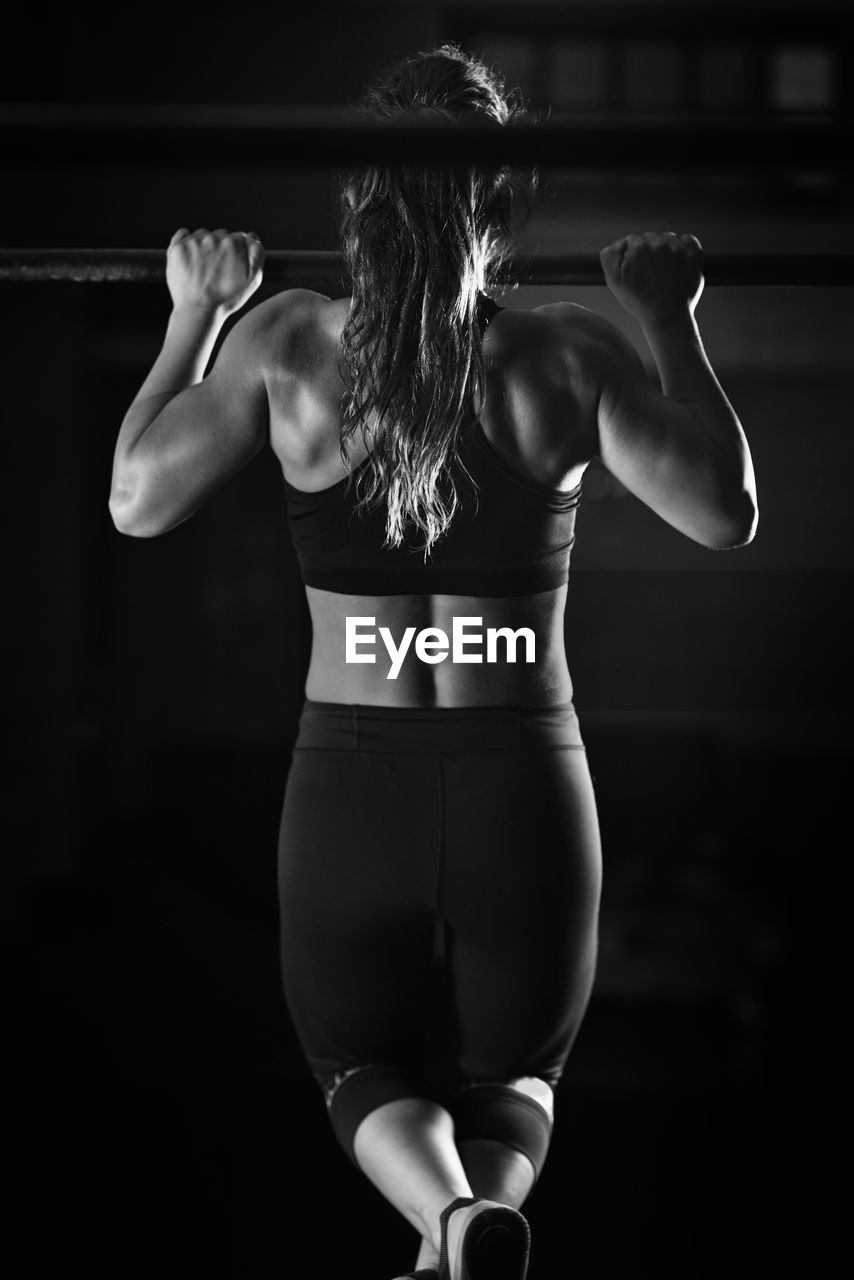 Rear view of woman exercising at gym