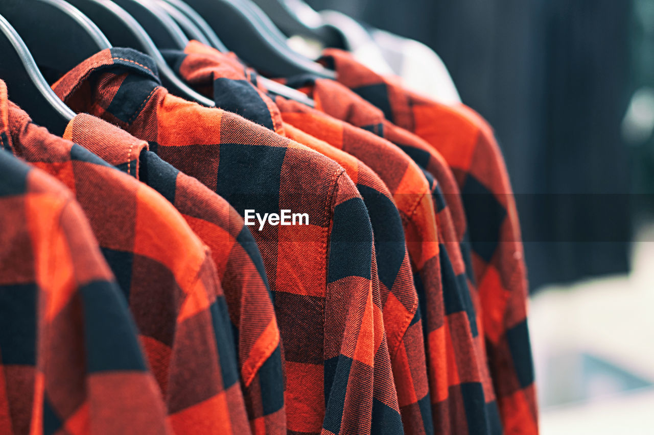 red, clothing, retail, in a row, orange, no people, textile, hanging, business finance and industry, large group of objects, business, market, multi colored, for sale, store, abundance, focus on foreground, close-up, day, variation, selective focus, order
