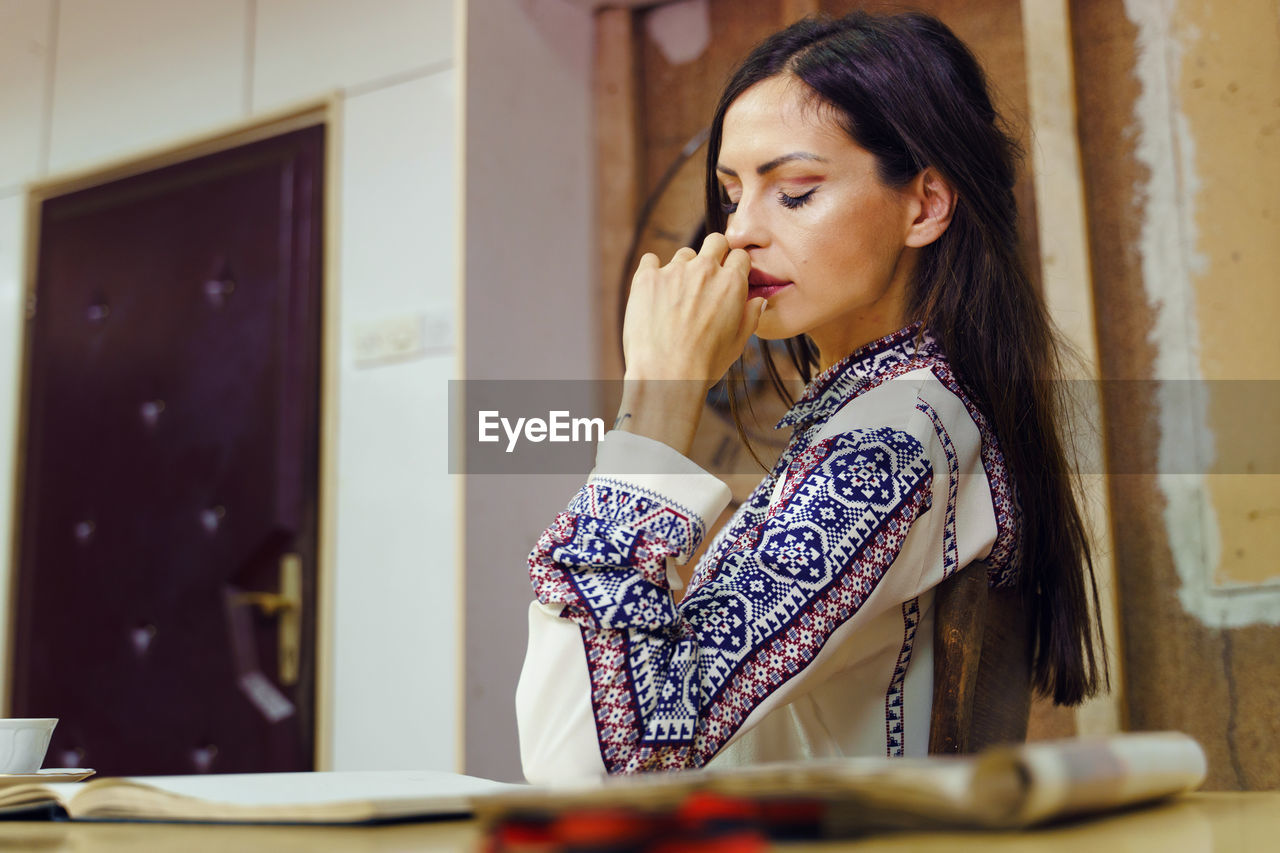 Woman looking away while standing on table