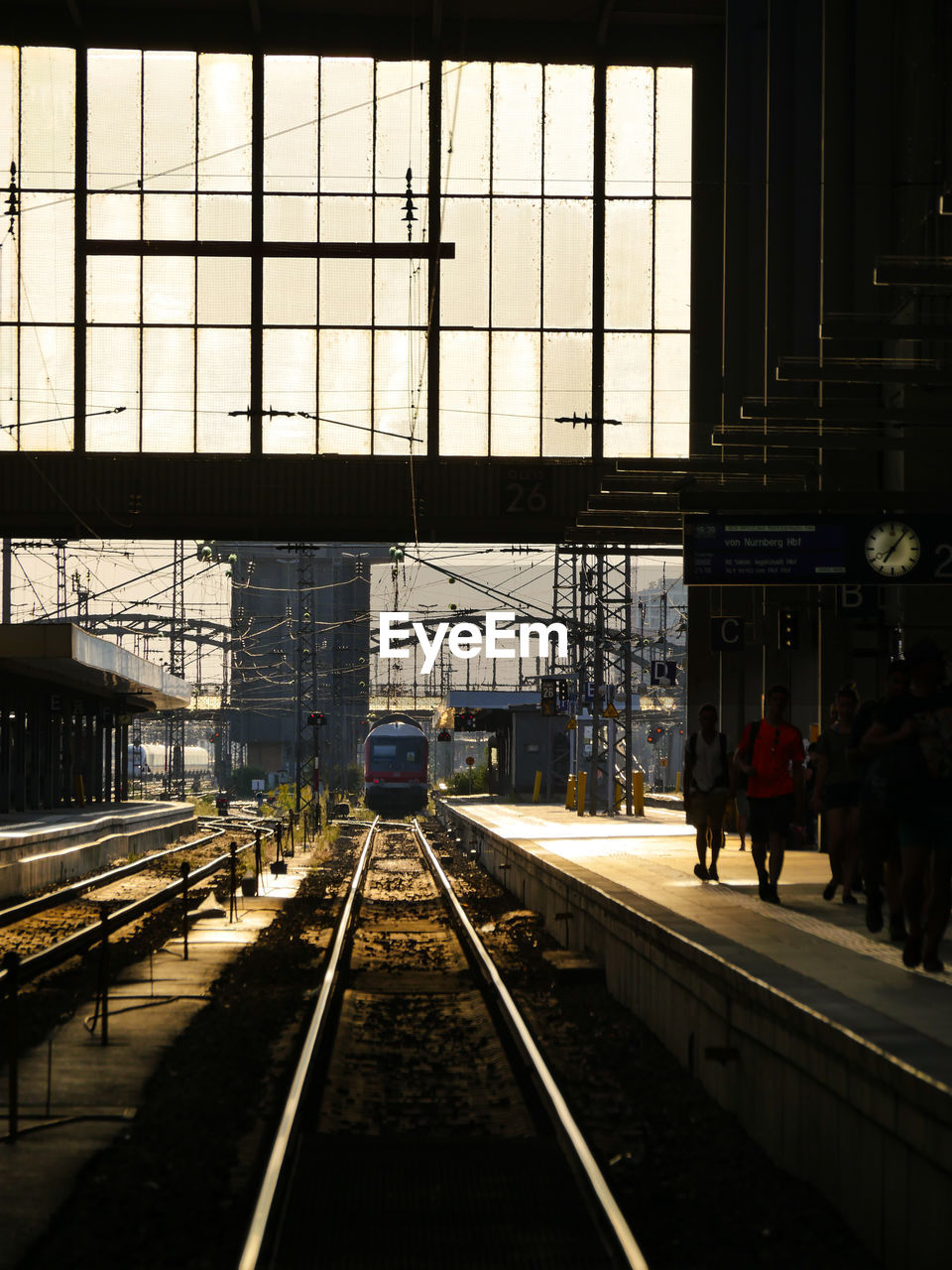 PEOPLE WALKING ON RAILROAD STATION PLATFORM