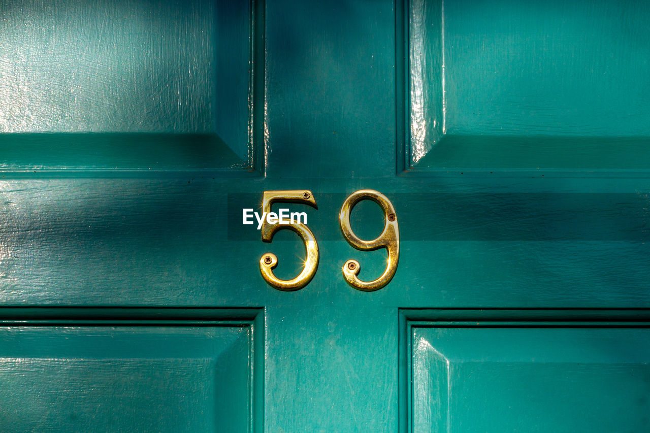 House number 59 on a turquoise wooden front door in london