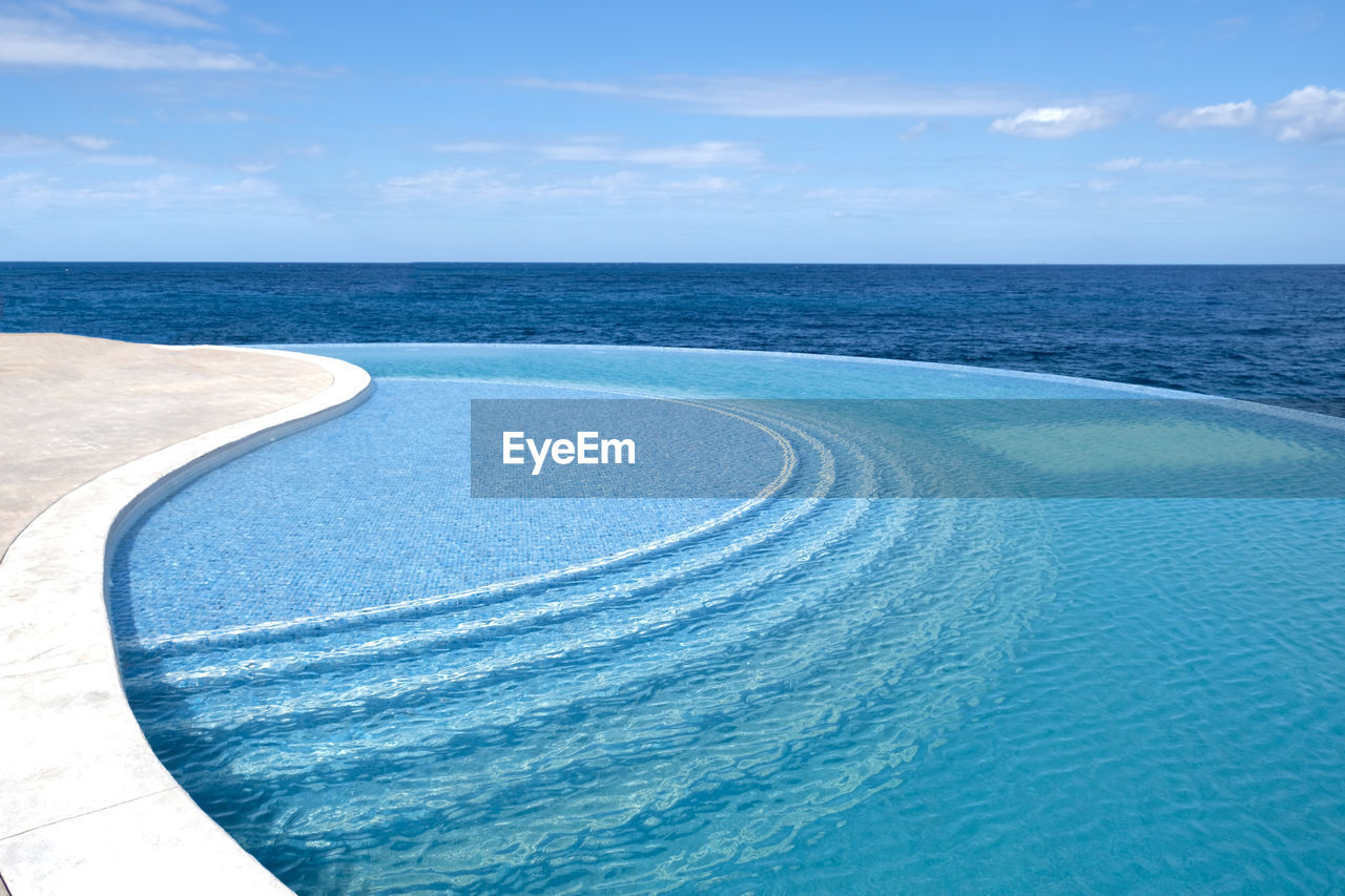 Sea water pool with stairs for relaxing, sea views. blue clear water surface in swimming pool. 