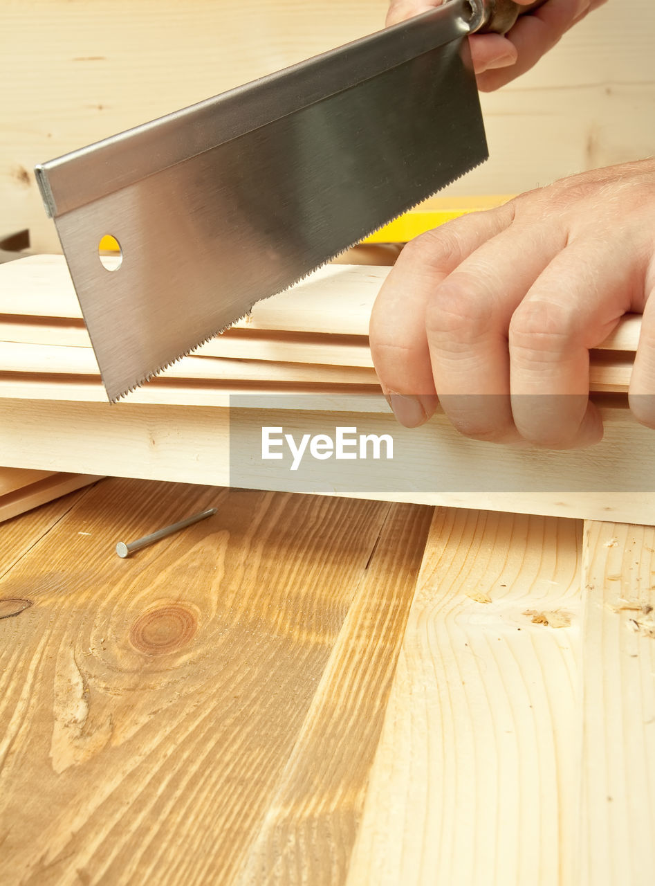 Close-up of carpenter cutting wood