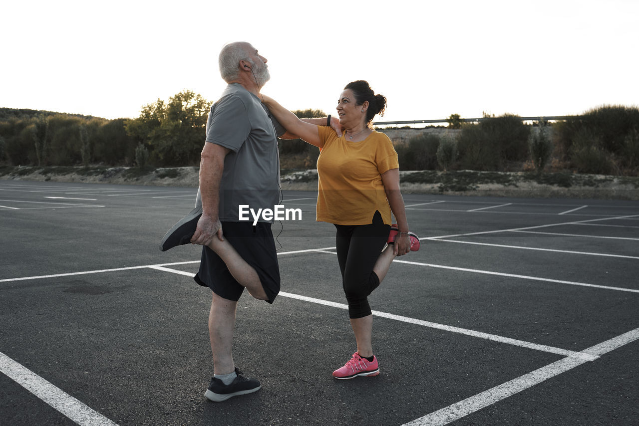 A middle-aged couple are doing stretching exercises together