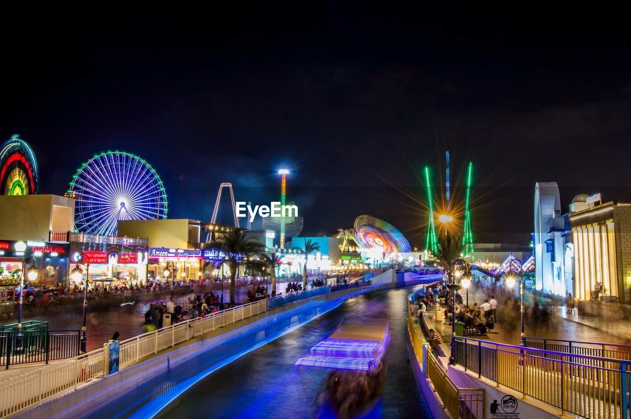 LIGHT TRAILS ON AMUSEMENT PARK AT NIGHT