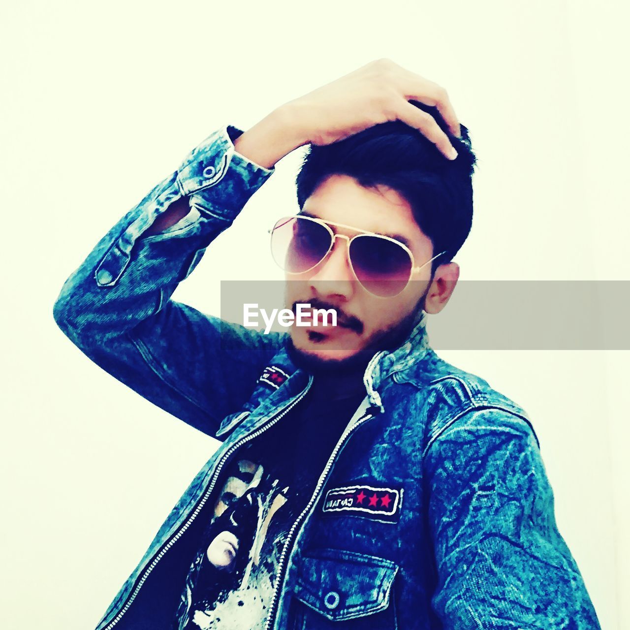 PORTRAIT OF MID ADULT MAN WEARING SUNGLASSES STANDING AGAINST WHITE BACKGROUND