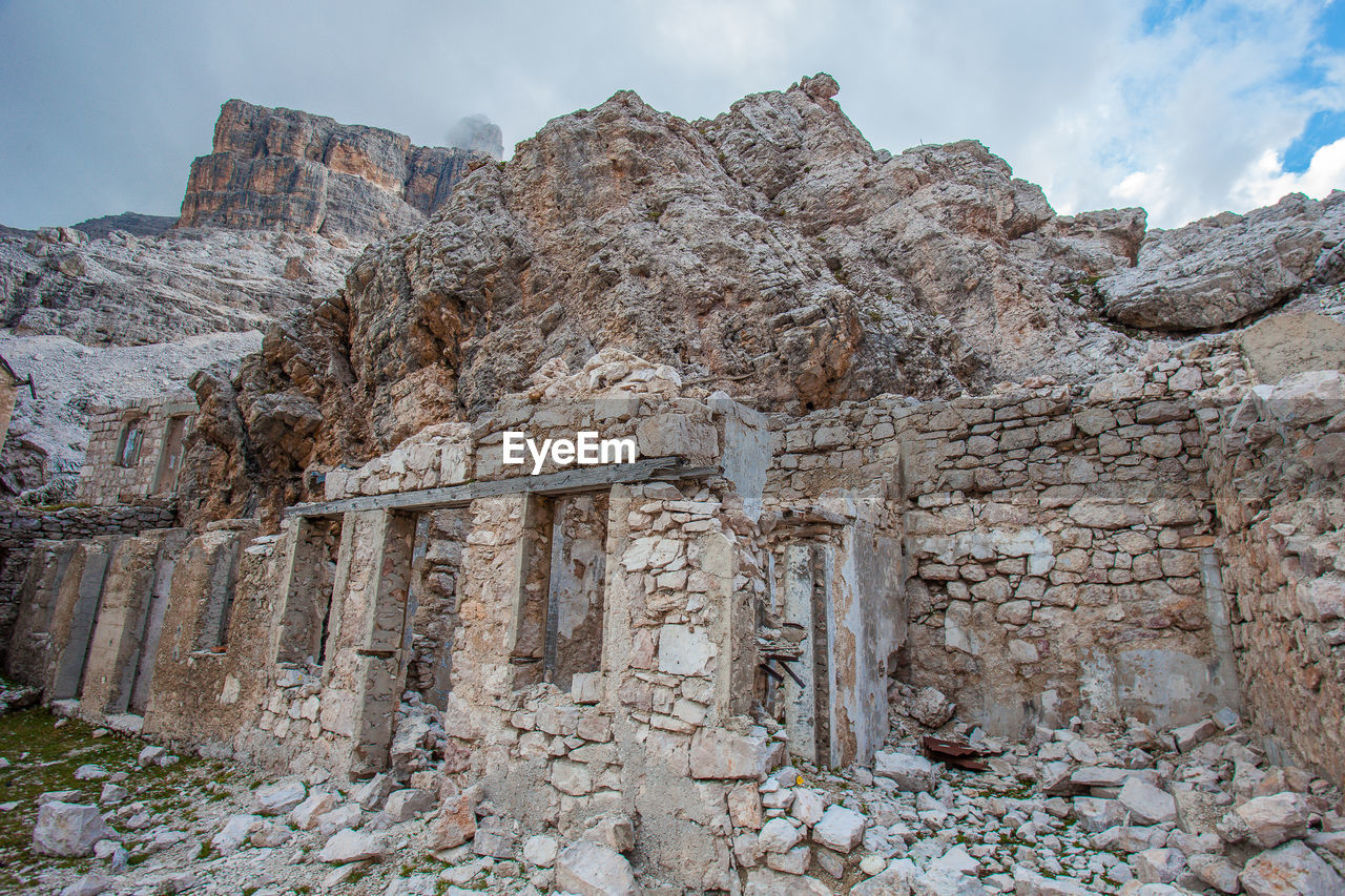 LOW ANGLE VIEW OF STONE WALL AGAINST MOUNTAIN RANGE