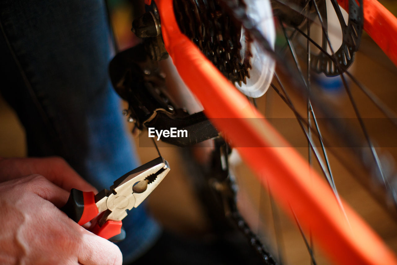 Hand of a man with a multitool near the wheel and brakes of the bike. bike repair, setting 