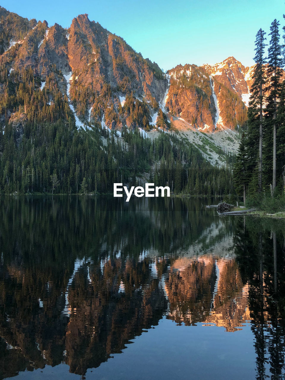 SCENIC VIEW OF LAKE BY TREES AGAINST MOUNTAIN