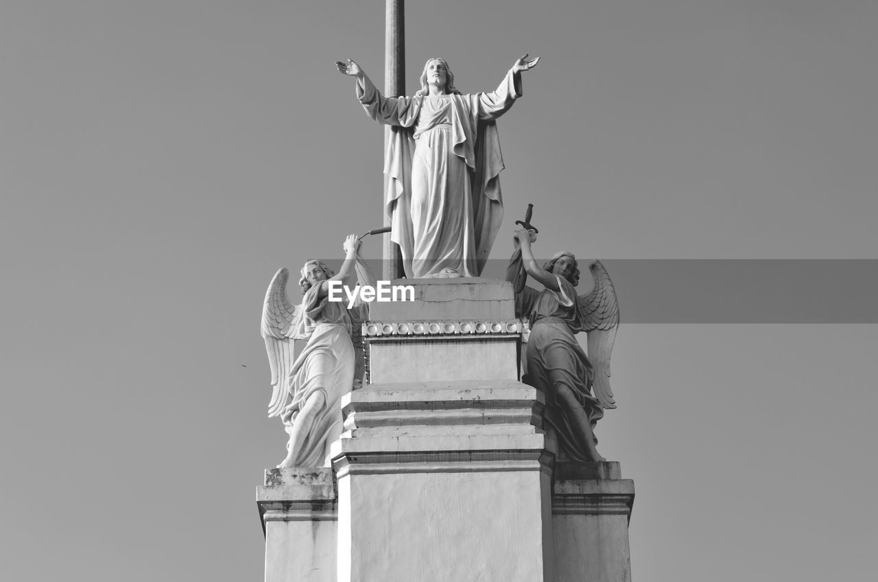 Low angle view of statues against sky