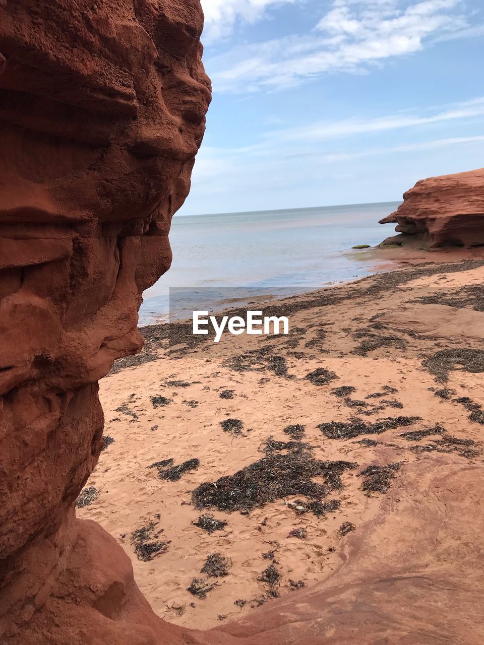 Rock formation on beach against sky