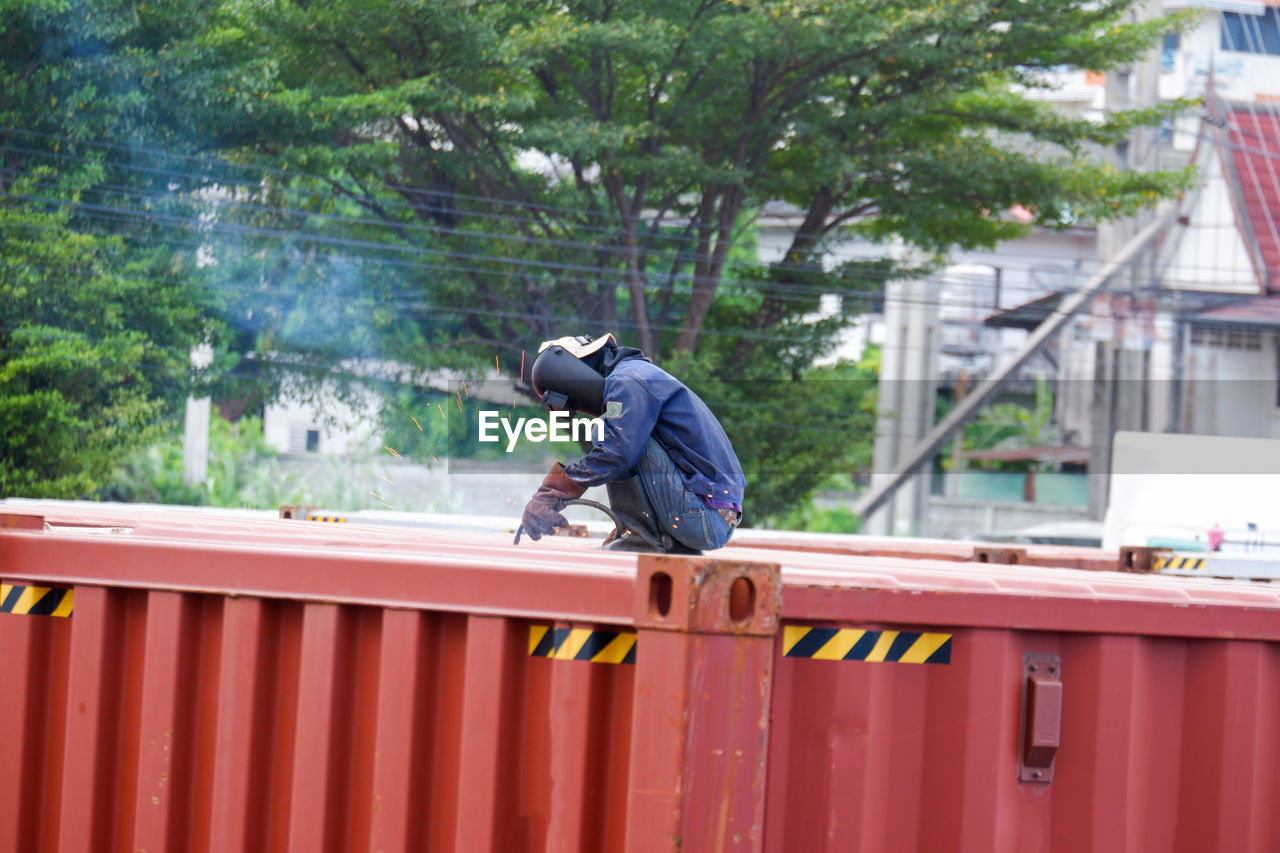 low angle view of young man standing against railing