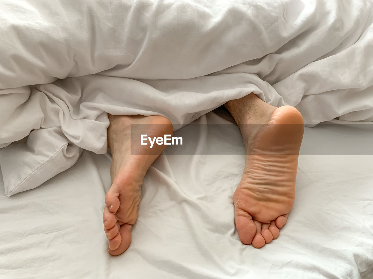 View of male feet, man sleeping at home. middle aged adult man is sleeping at home. cozy bedroom