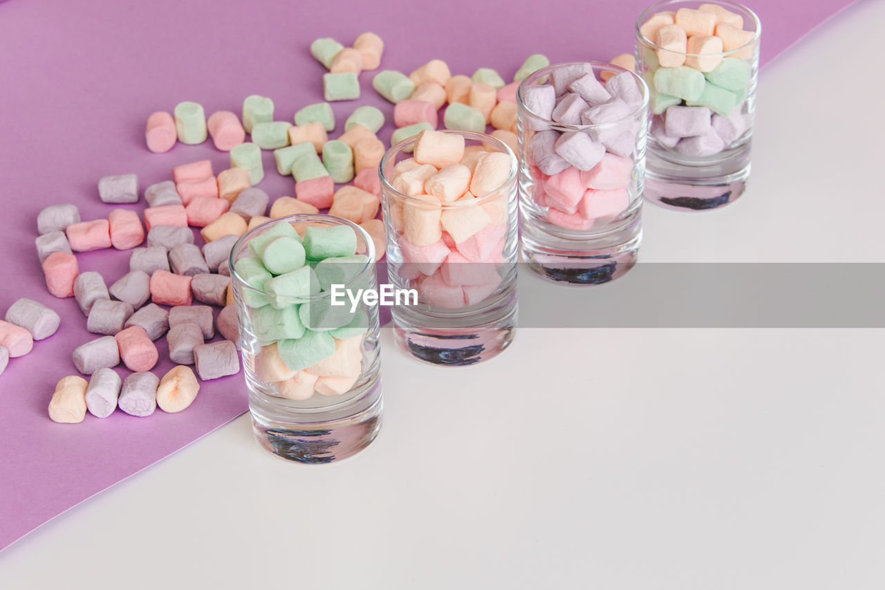 HIGH ANGLE VIEW OF MULTI COLORED CANDIES ON TABLE