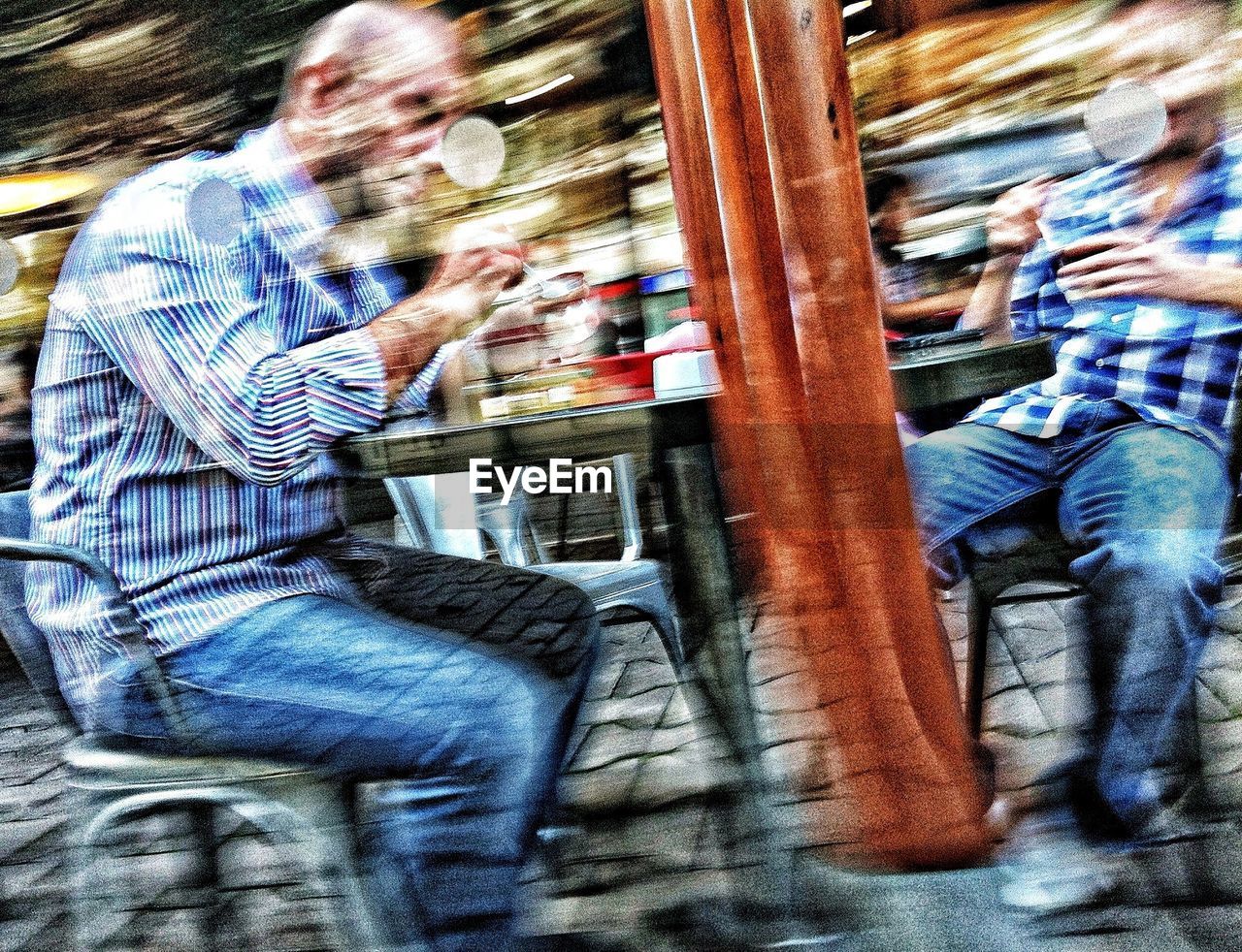 blurred motion, real people, casual clothing, public transportation, buying, lifestyles, men, retail, consumerism, two people, customer, motion, supermarket, city, day, women, outdoors, carousel, adult, people, adults only