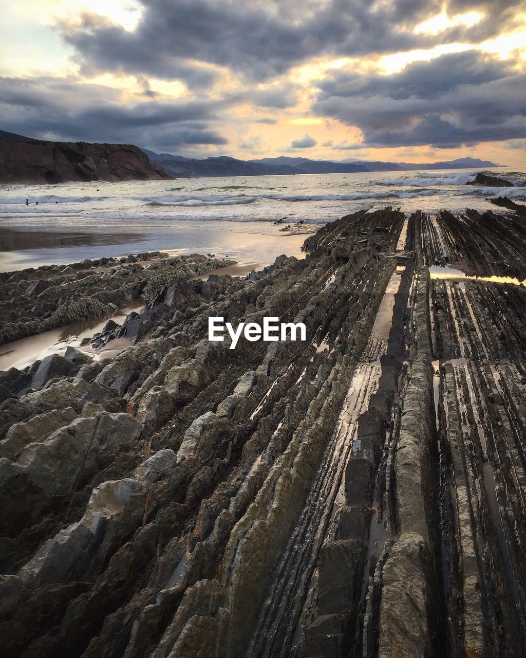 High angle view of rocky shore against cloudy sky at acantilado flysch