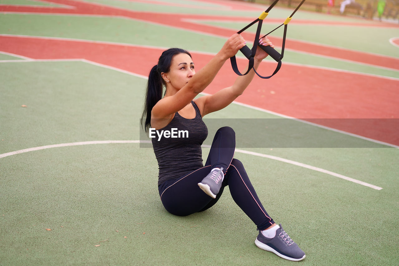 Woman exercising with equipment at court