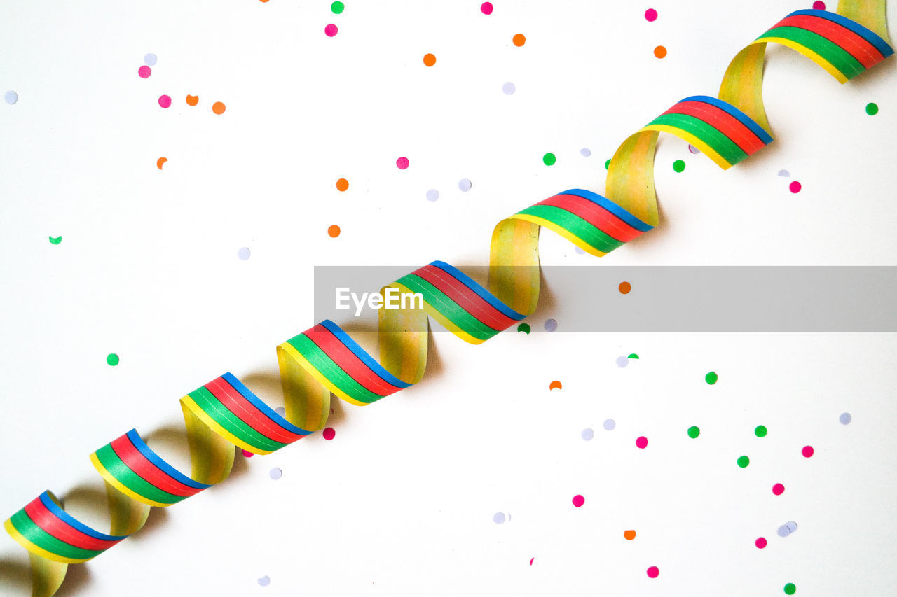 HIGH ANGLE VIEW OF MULTI COLORED CANDIES ON WHITE TABLE