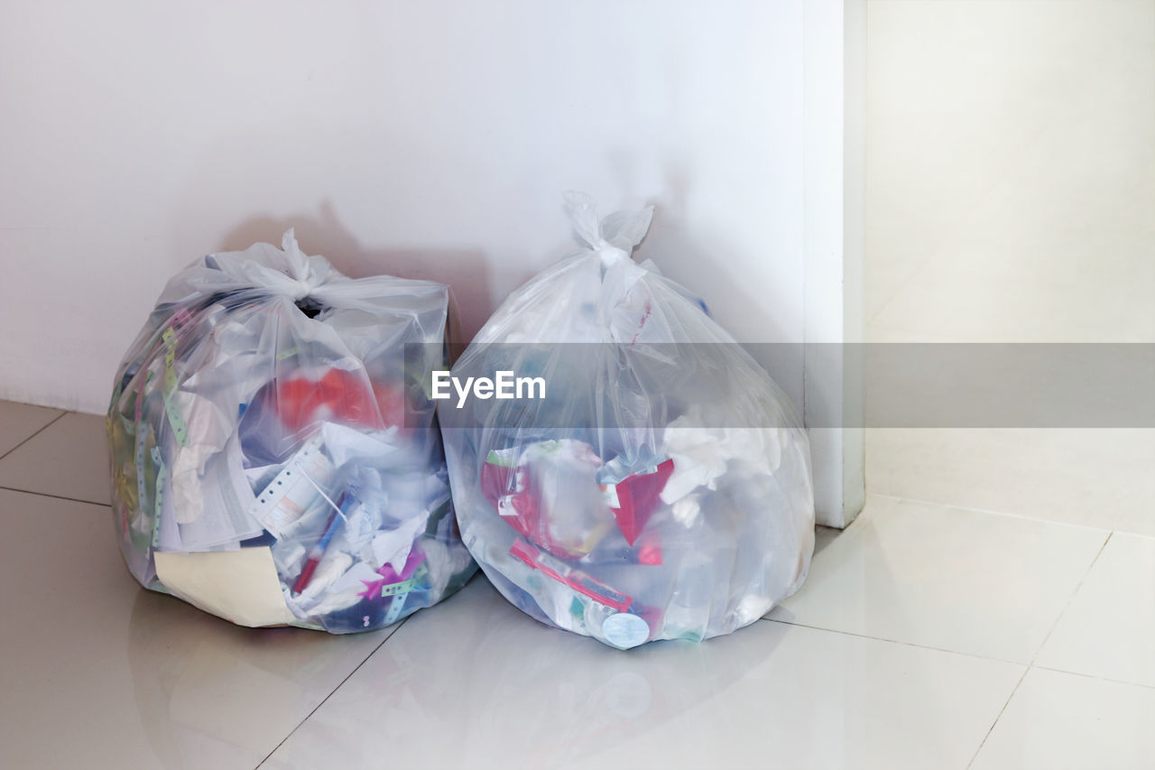 Garbage in plastic bags on tiled floor at home