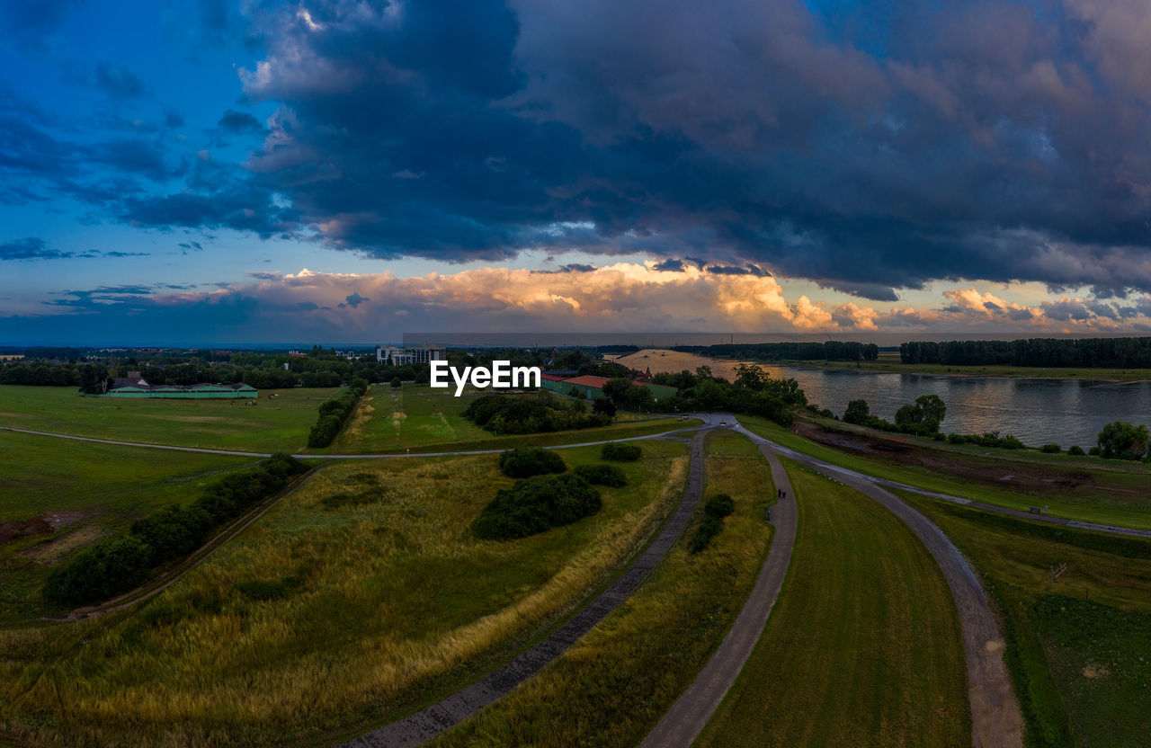 Panoramic view of road amidst field against sky during sunset