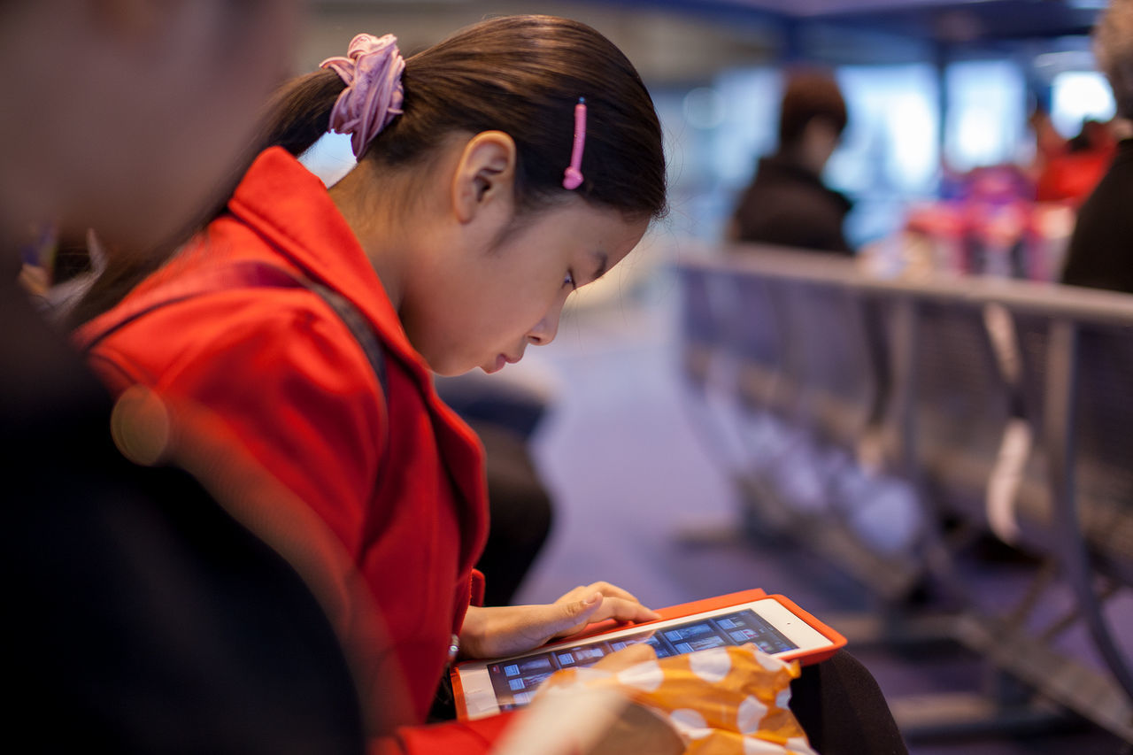 Woman looking into tablet while sitting at airport