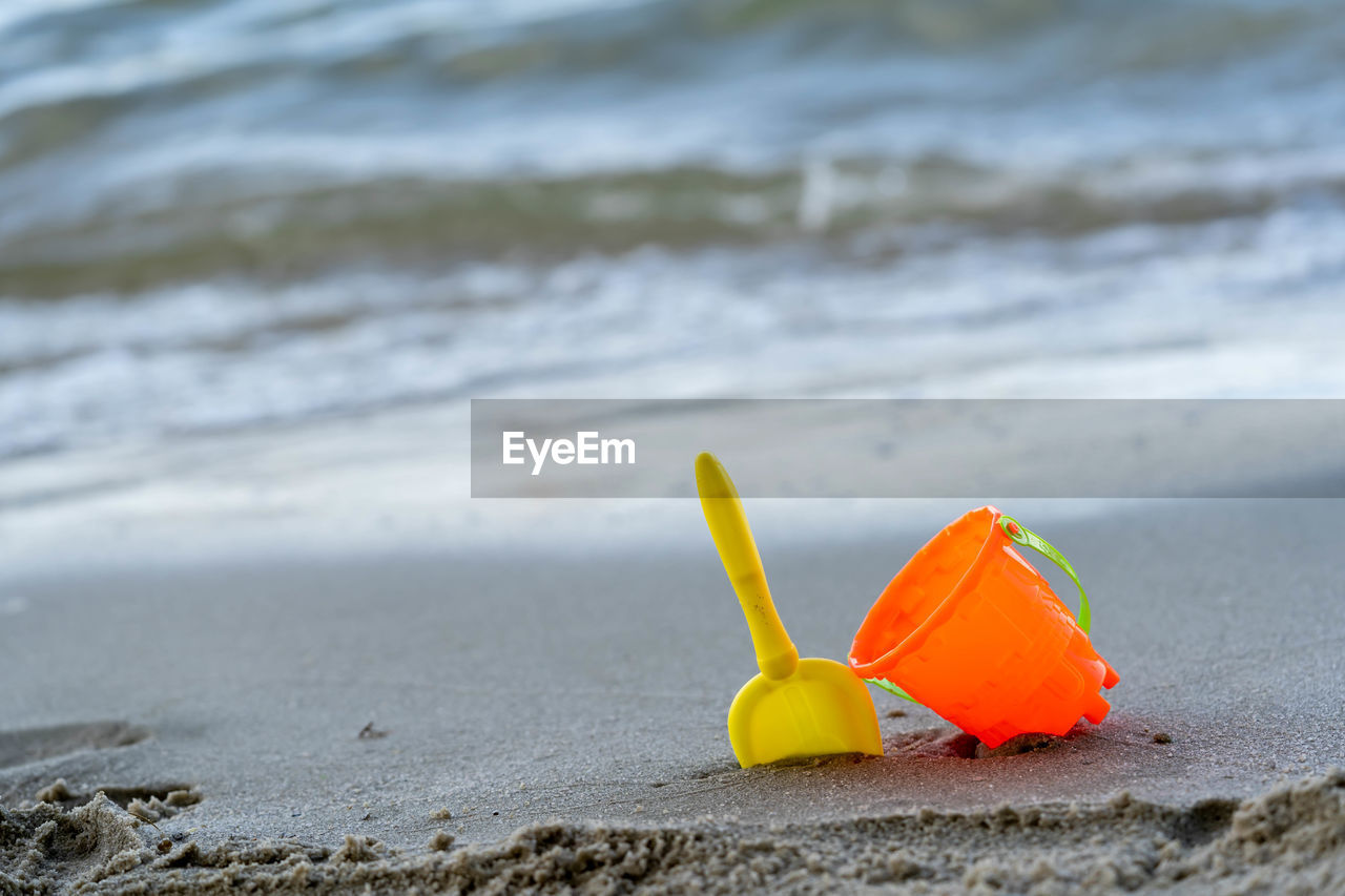 CLOSE-UP OF YELLOW TOY ON SAND