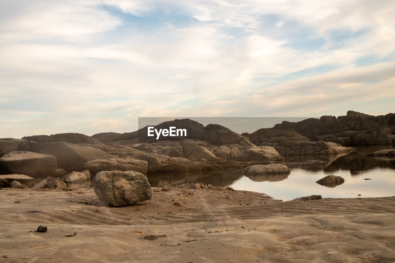 Scenic view of rocks on beach against sky