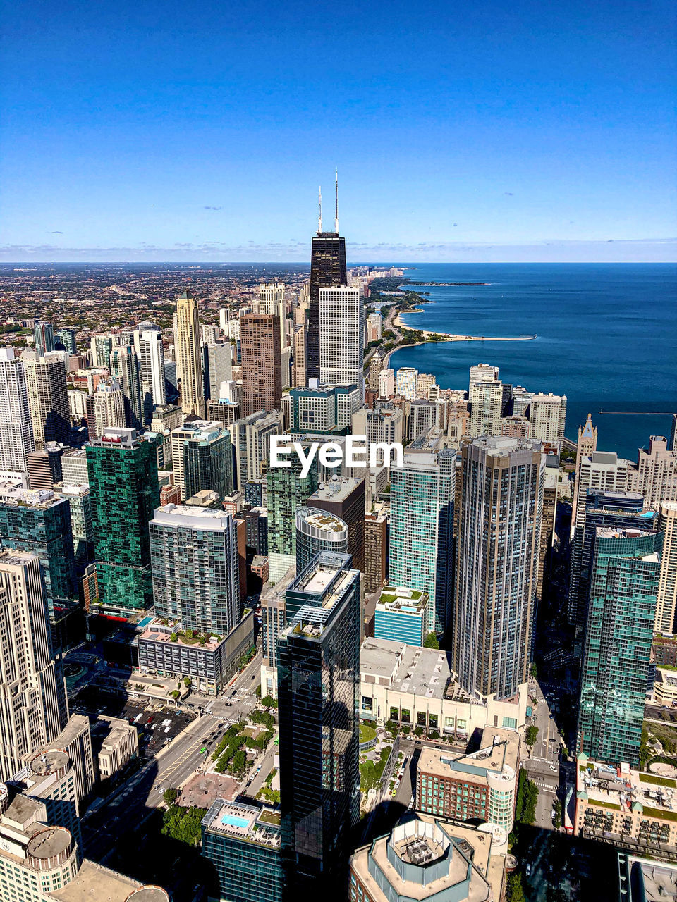 HIGH ANGLE VIEW OF MODERN BUILDINGS BY SEA AGAINST SKY