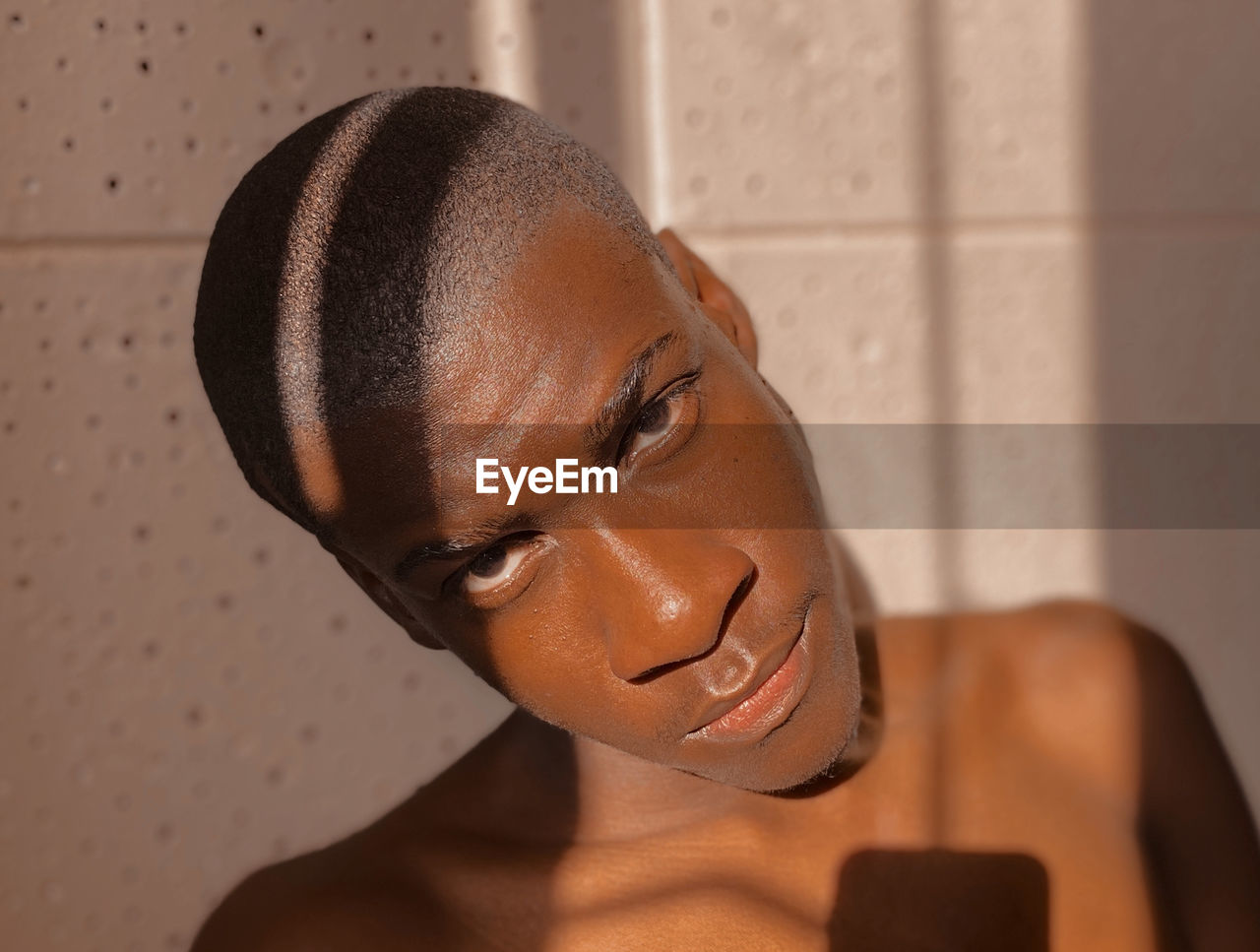 Close-up portrait of young man against wall