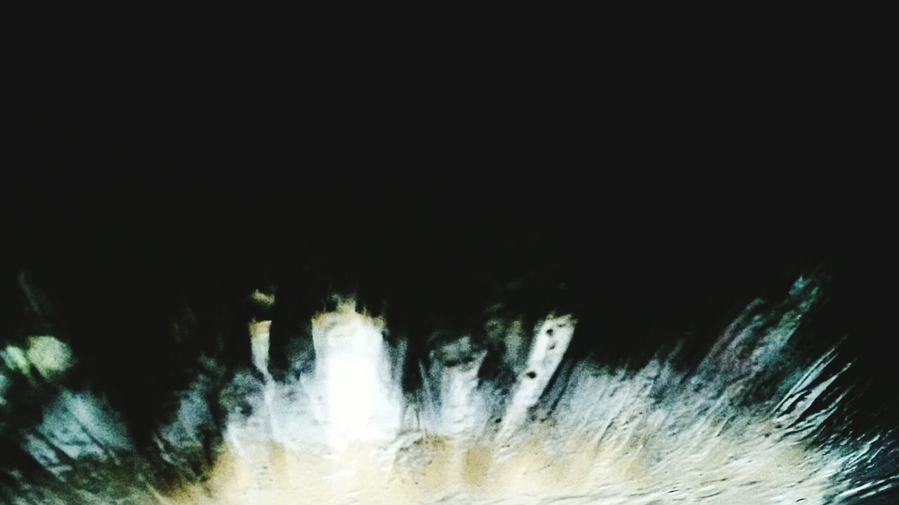 WATER SPLASHING IN BLACK AGAINST BLURRED BACKGROUND