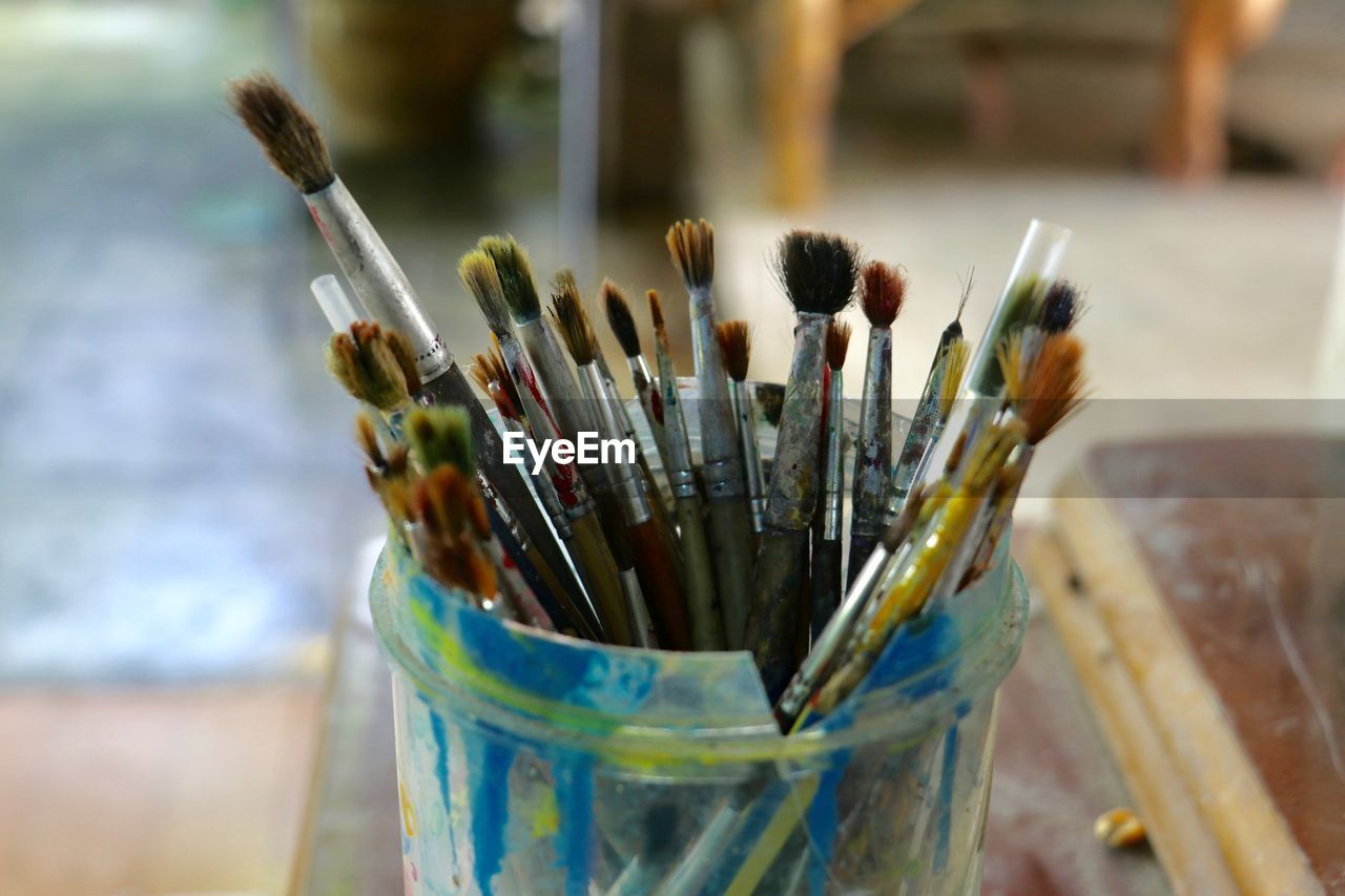 CLOSE-UP OF PAINTBRUSHES IN CONTAINER