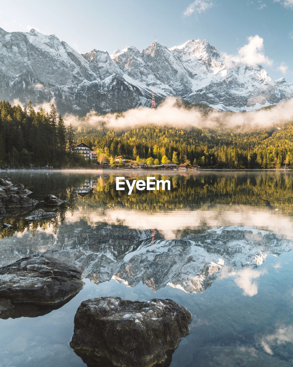 Scenic view of lake by snowcapped mountains against sky