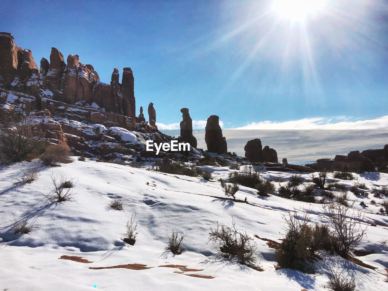 Scenic view of snowcapped mountains against sky on sunny day