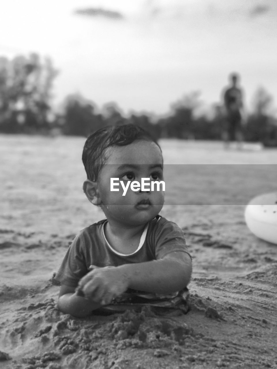 Close-up of baby boy in sand