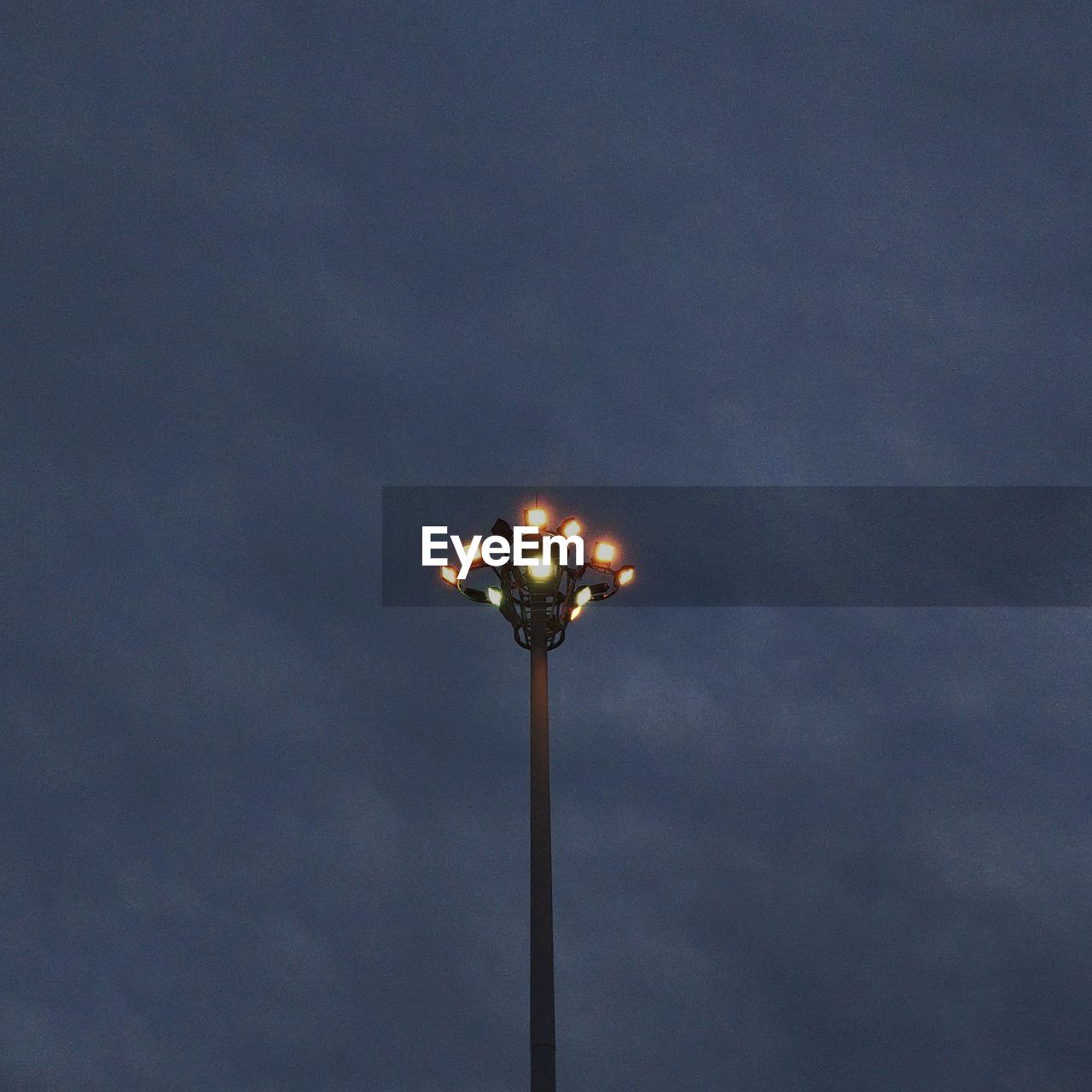 LOW ANGLE VIEW OF ILLUMINATED STREET LIGHTS AGAINST SKY AT NIGHT