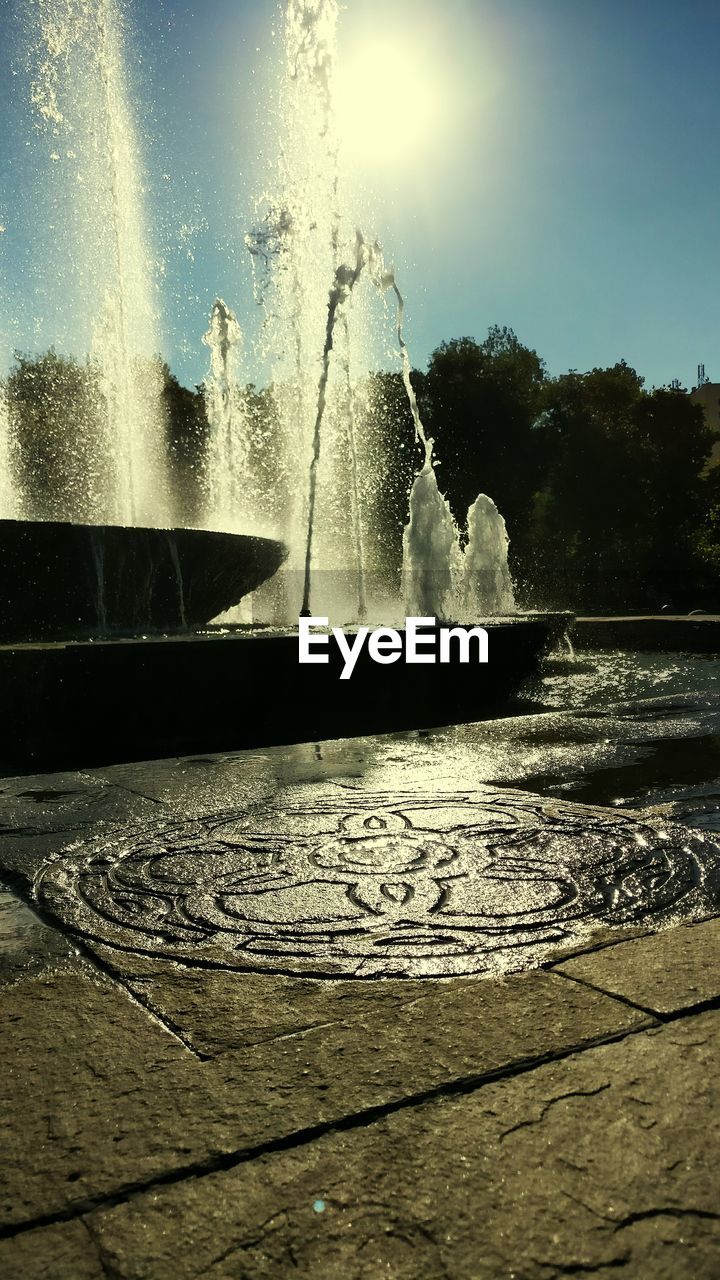 Scenic view of fountain in park against clear sky