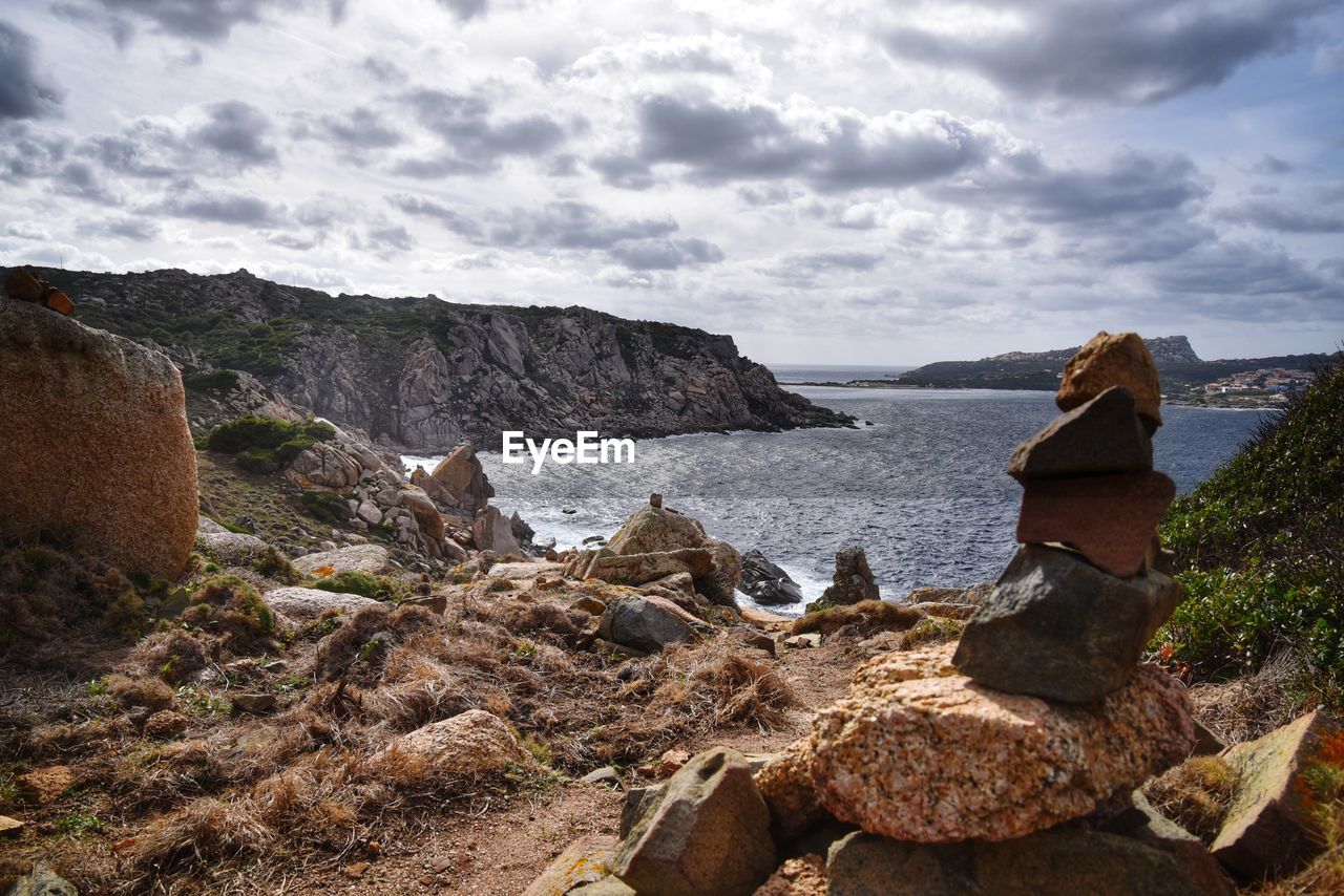 Rock formations on shore against sky