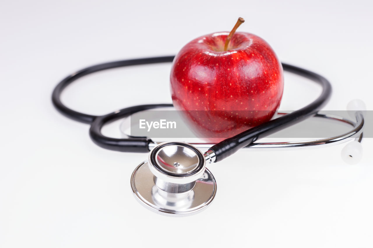 CLOSE-UP OF RED FRUIT ON WHITE BACKGROUND