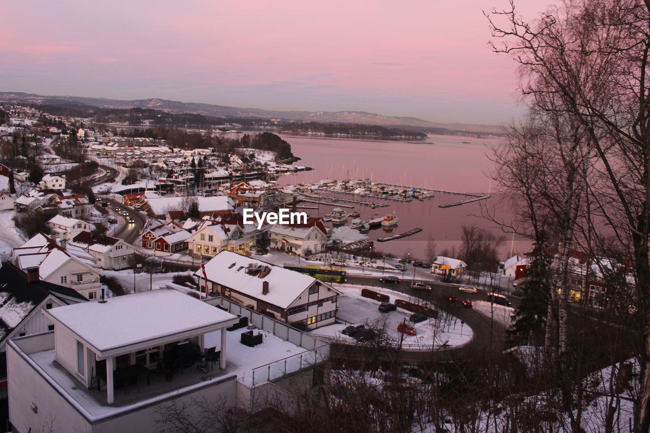 High angle view of town by sea against sky