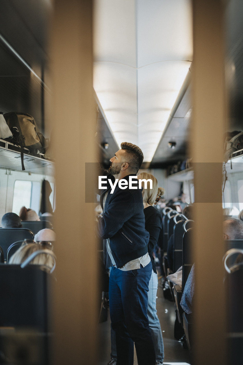 Man loading luggage while standing in train