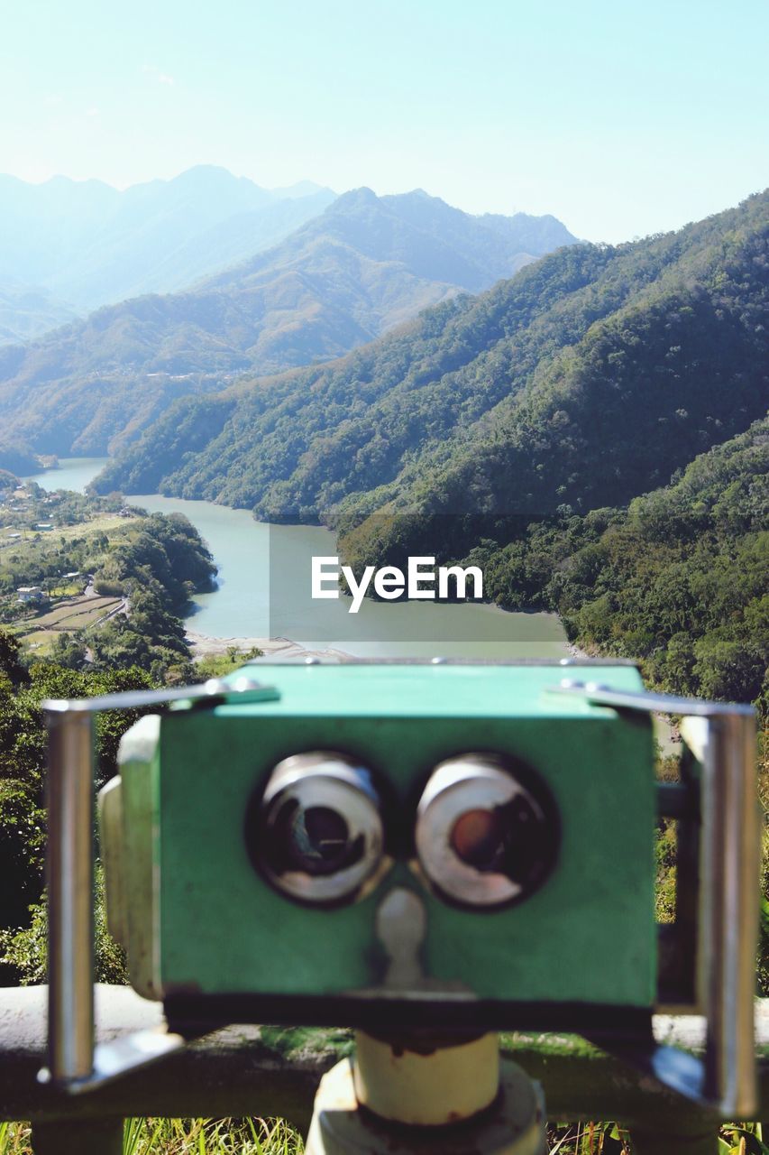 CLOSE-UP OF CAR AGAINST MOUNTAINS