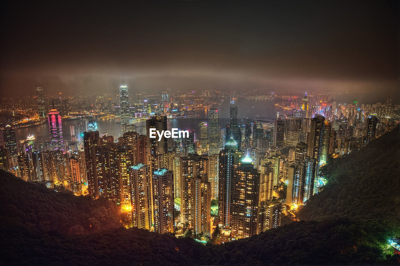 High angle view of illuminated cityscape against sky at night