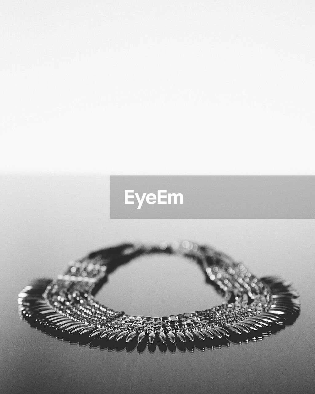 Close-up of necklace on table against white background