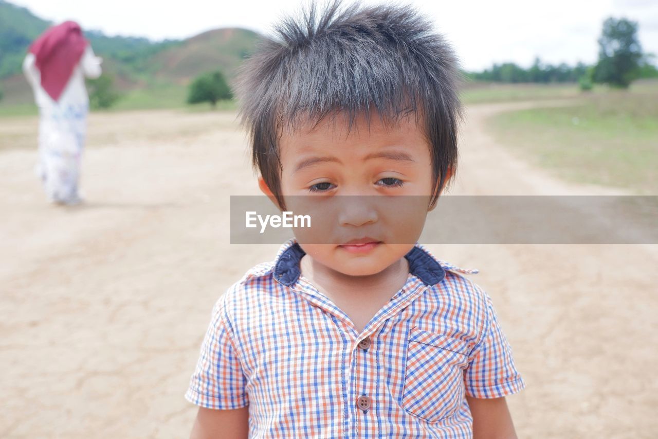 Portrait of cute boy standing on land